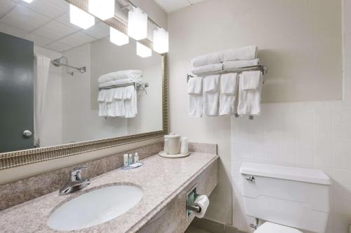 a bathroom with a sink and a toilet and a mirror at Quality Inn Joliet in Joliet