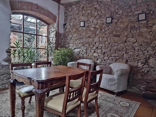a wooden table and chairs in a room with a stone wall at Holiday Home U Černých Ovcí in Náměšť nad Oslavou