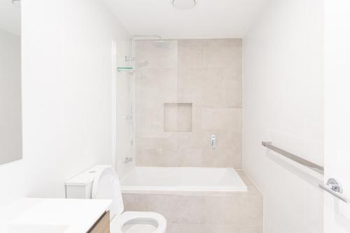 a white bathroom with a tub and a toilet at Chapel Heights Apartments in New Lambton