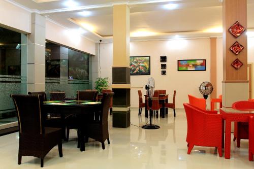 ein Esszimmer mit Tischen und roten Stühlen in der Unterkunft Musdalifah Hotel in Nambakor