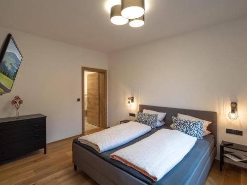 1 dormitorio con 1 cama y vestidor en Bergzeit Appartement, en Hopfgarten im Brixental