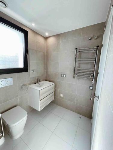 a bathroom with a toilet and a sink and a window at NEW GROUNDFLOOR APT. ARENALES DEL SOL in Arenales del Sol