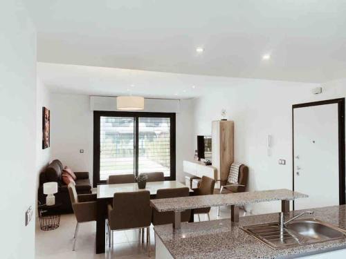 een keuken en een woonkamer met een tafel en stoelen bij NEW GROUNDFLOOR APT. ARENALES DEL SOL in Arenales del Sol