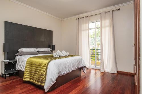 a bedroom with a large bed with a yellow blanket at Bela Vista Sea View in Venda do Atalhinho