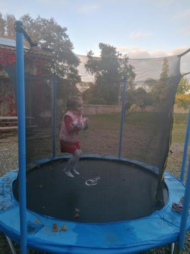 une petite fille jouant sur un trampoline dans l'établissement Les Amandiers de Jade, à Saint-Agnet
