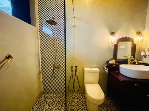 a bathroom with a shower and a toilet and a sink at Rosewood Manor in Botiyatenna