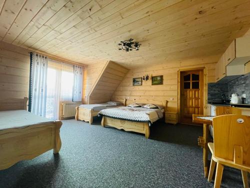 een slaapkamer met 2 bedden in een houten kamer bij U Maćka in Poronin