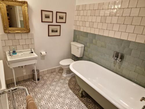 a bathroom with a tub and a toilet and a sink at Cambus O' May Hotel in Ballater