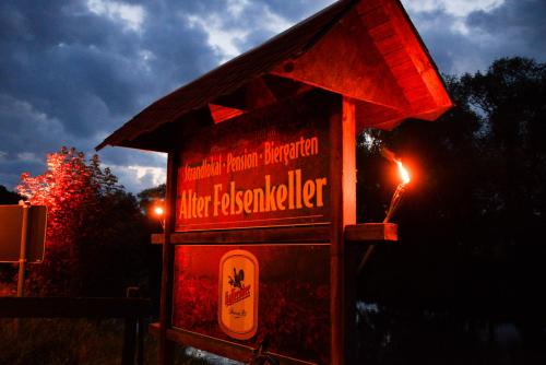 a sign that is lit up at night at Gasthof Alter Felsenkeller in Naumburg