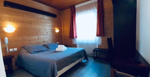 Schlafzimmer mit einem Bett und einem Fenster in der Unterkunft Hôtel Bel Angle in Les Angles