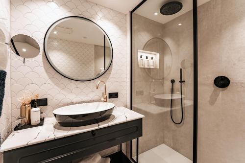 a bathroom with a sink and a shower at Strandhotel Kurhaus Juist in Juist