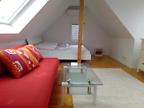 sala de estar con sofá rojo y cama en Sonnen-Apartment en Bad Honnef am Rhein