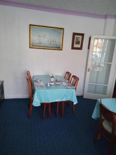 een eetkamer met een tafel met een pop erop bij Applebys Guest House in Holyhead