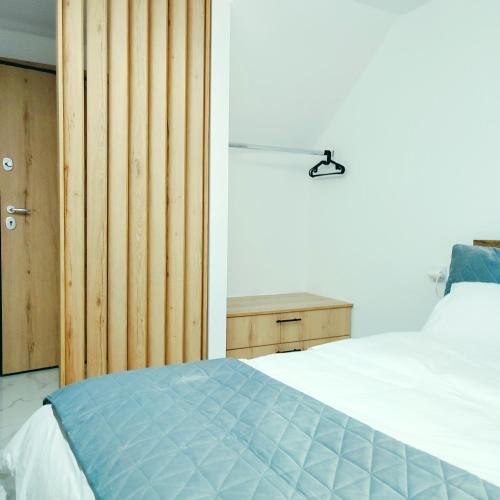 1 dormitorio con 1 cama y pared de madera en Unique Apartment Ioannina, en Ioannina
