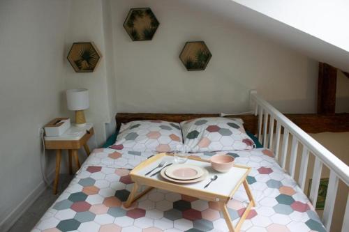 una piccola camera da letto con un letto e un tavolo con un piatto sopra di Cosy à Guist'hau a Nantes