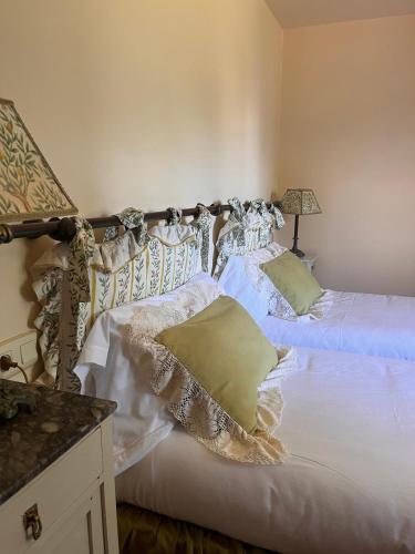 a bedroom with two beds with white sheets and a lamp at Palacio de Cutre in La Goleta