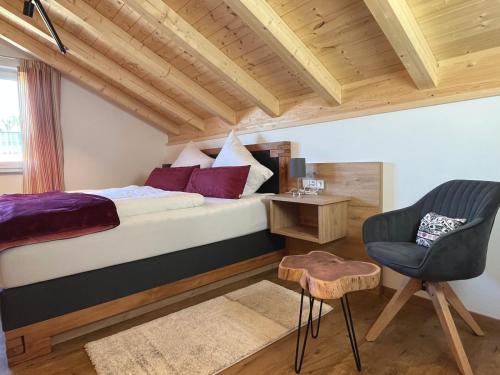 1 dormitorio con 1 cama y 1 silla en Sunnefleackle -Haus Lingenhöl, en Sonthofen