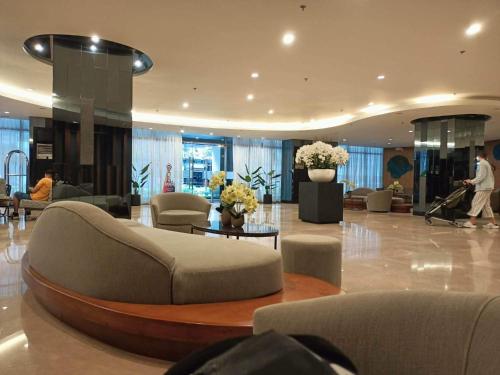 a lobby with a couch and chairs in a building at Your home in the city in Manila