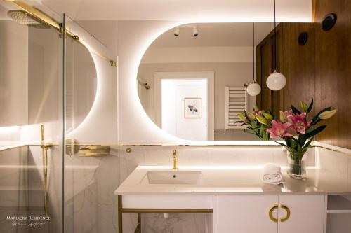 La salle de bains est pourvue d'un lavabo et d'un miroir. dans l'établissement Mariacka Residence, à Gdańsk
