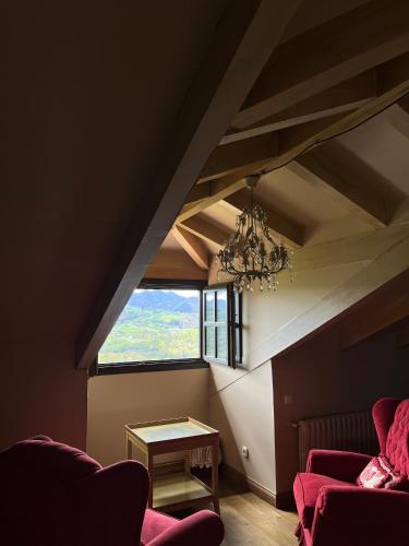 an attic room with a chandelier and a table at Palacio de Cutre in La Goleta