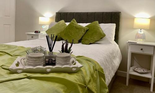 a bed with a tray with plates and dishes on it at Cosy Bungalow Near Open Countryside in Felixstowe