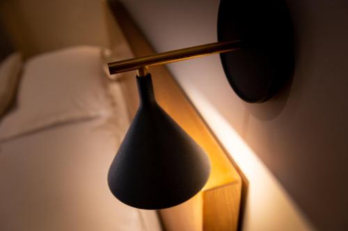 a black lamp sitting next to a bed at Couvent de la Salette & Spa in Millau