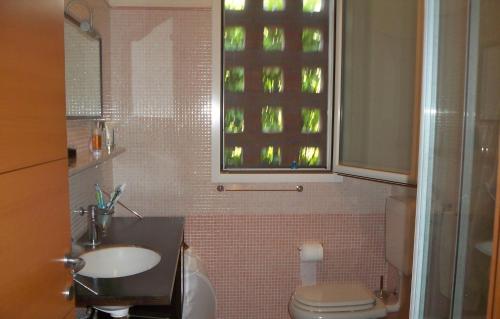 a bathroom with a sink and a toilet and a window at Gardazzurro in Padenghe sul Garda