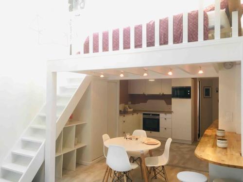 a white loft bed with a table and chairs in a kitchen at Cosy à Guist'hau in Nantes