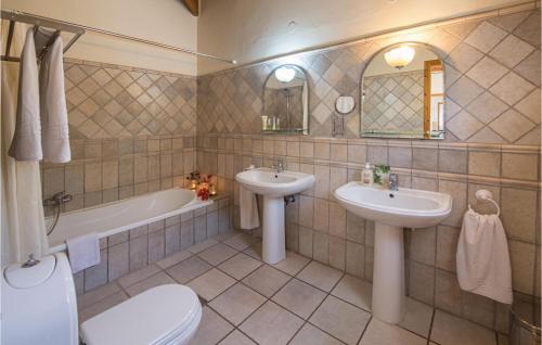 a bathroom with two sinks and a tub and a toilet at Villa Sophia in Évyiros