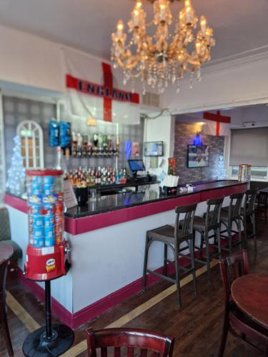 a bar in a restaurant with chairs and a chandelier at MyRoomz Hollingdales Hotel in Blackpool