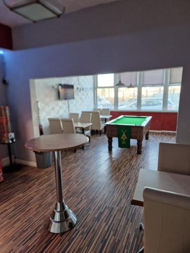 a waiting room with a pool table and chairs at MyRoomz Hollingdales Hotel in Blackpool