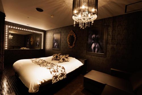 旭川的住宿－旭川ホテルユニオン-大人専用，一间卧室配有一张床和一个吊灯