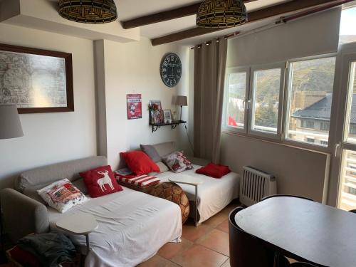 Cette chambre comprend deux lits, un canapé et une table. dans l'établissement Apartamento Plaza Pradollano 2, à Sierra Nevada
