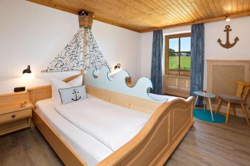 ein Schlafzimmer mit einem großen Bett mit einem Kronleuchter in der Unterkunft Salenberghof Ferienwohnung Panorama in Rieden