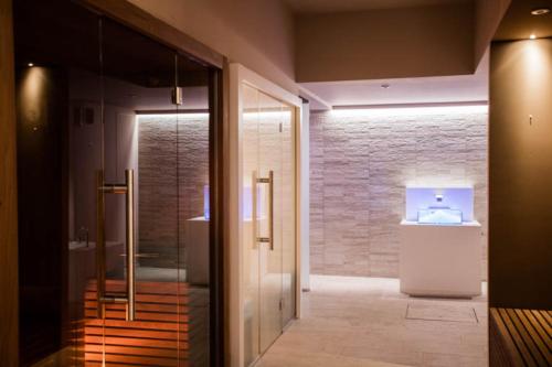 巴薩諾－德爾格拉帕的住宿－Hotel Alla Corte SPA & Wellness Relax，一间带步入式淋浴间和玻璃门的浴室