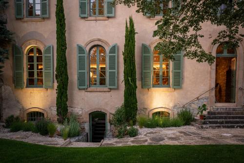 a house with green shutters and a yard at Couvent de la Salette & Spa in Millau