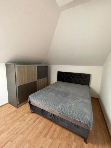 1 dormitorio con 1 cama y suelo de madera en Despot apartmani, en Mladenovac