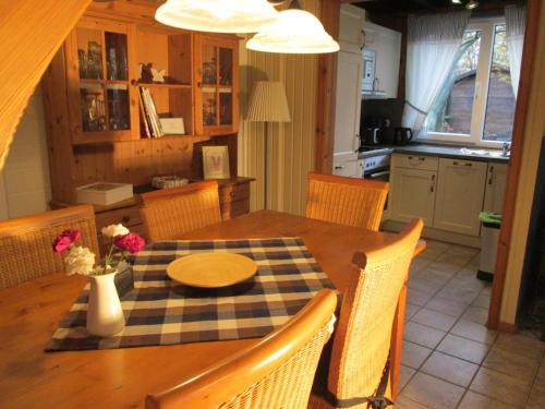 uma cozinha com uma mesa de madeira com cadeiras e uma sala de jantar em Haus Mika em Rott