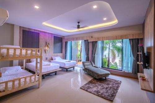 a bedroom with two bunk beds and a couch at Mangrovebay Krabi Beachfront Pool Villa in Ban Nai Sa
