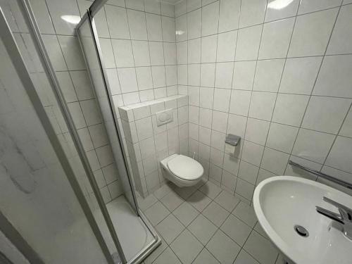 ein weißes Bad mit einem WC und einem Waschbecken in der Unterkunft Beny Hotel Restaurant in Bad Bellingen
