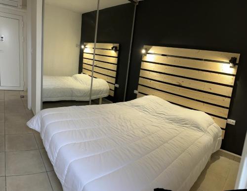 sypialnia z 2 łóżkami i lustrem w obiekcie T2 RESIDENCE NATURISTE Aphrodite Leucate w mieście Leucate