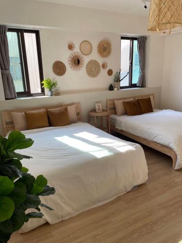 two beds in a room with windows at 出水茶旅民宿 in Zhuqi