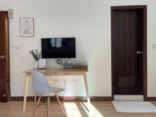 a room with a desk with a television and a chair at 出水茶旅民宿 in Zhuqi