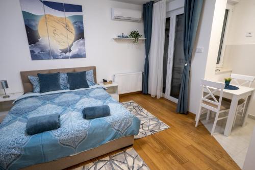 a bedroom with a bed and a table and a desk at Sky Apartments Novi Sad in Novi Sad
