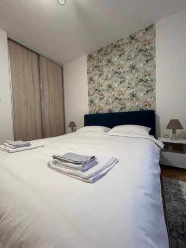 a bedroom with a white bed with towels on it at Vert Apartment in Banja Luka