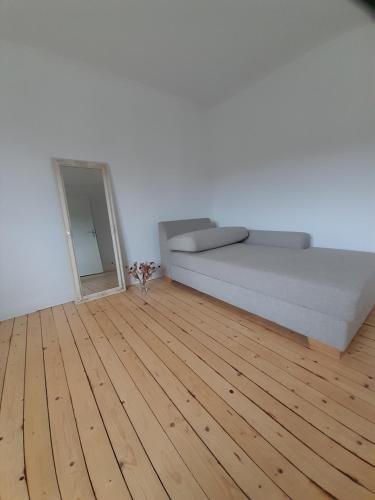 1 dormitorio con 1 cama y suelo de madera en TannenQuartier - Ihr Ferienhäuschen, en Groß Grönau