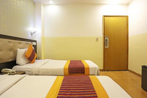 a hotel room with two beds and a door at Hotel Aeroporto in New Delhi