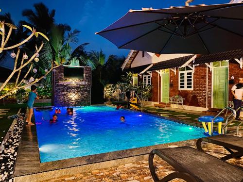 a group of people in a swimming pool at night at Gading Chalet in Kuala Terengganu