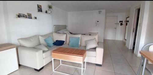 sala de estar con sofá blanco y mesa en Departamento Plaza Mitre en Mar del Plata