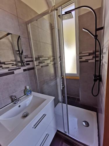 a bathroom with a shower and a sink and a mirror at Studio 2 personnes in Le Mont-Dore